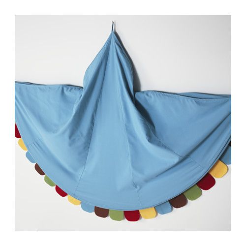 a blue kite hanging on the wall with multicolored pom poms around it