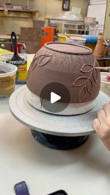 someone is making a hat out of clay on a table with cell phones and other items