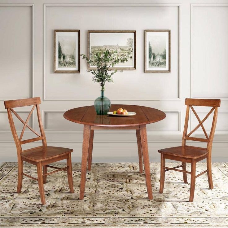 a small table with two chairs and a bowl of fruit on top of the table