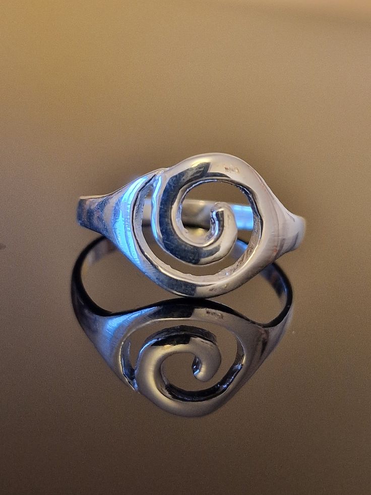 This is a beautifully handmade flat spiral ring, a stunningly simple design that is made with love and care.  This stunning statement ring is both light and easy to wear as well as being a very impressive and eye-catching design.   This ring comes gift wrapped and would make an ideal birthday gift, Valentine's Day Gift, Mother's Day Gift, anniversary gift or for any occasion. The spiral is the age-old intuitive symbol of spiritual development and our identity with the universe. It is found in cu Handmade Silver Rings Simple, Modern Twist Swirl Jewelry As Gift, Gift Spiral Ring With A Modern Twist, Modern Spiral Rings As A Gift, Spiral Rings With Unique Design For Gifts, Modern Spiral Rings As Gifts, Modern Twist Swirl Jewelry For Gift, Modern Twist Swirl Ring As Gift, Modern Twist Swirl Ring For Gift