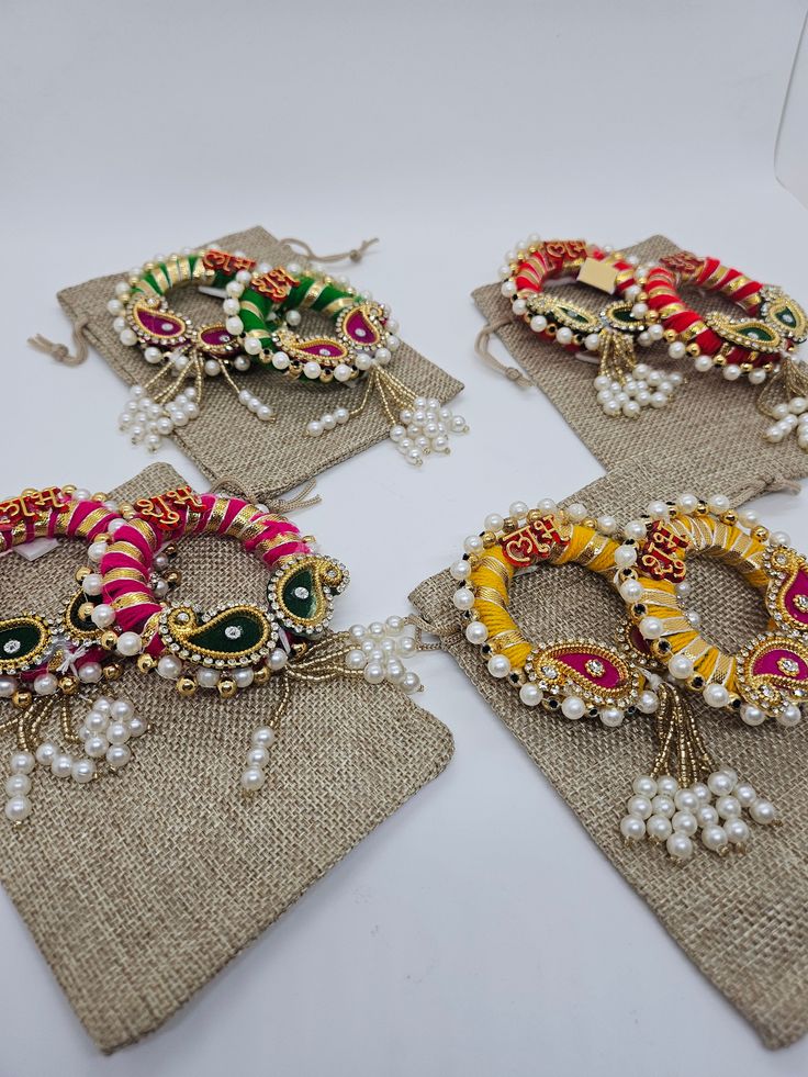 four pairs of colorful bracelets on burlock with pearls and beads are displayed