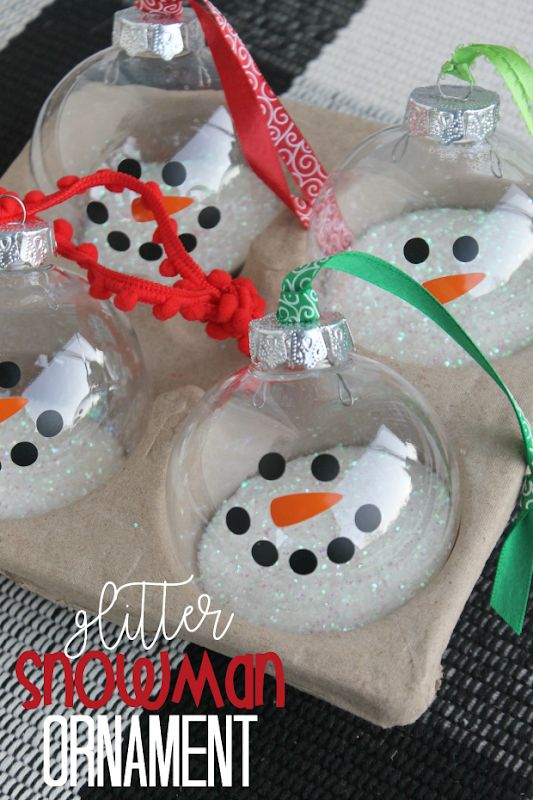 three snowman ornaments are sitting on a tray