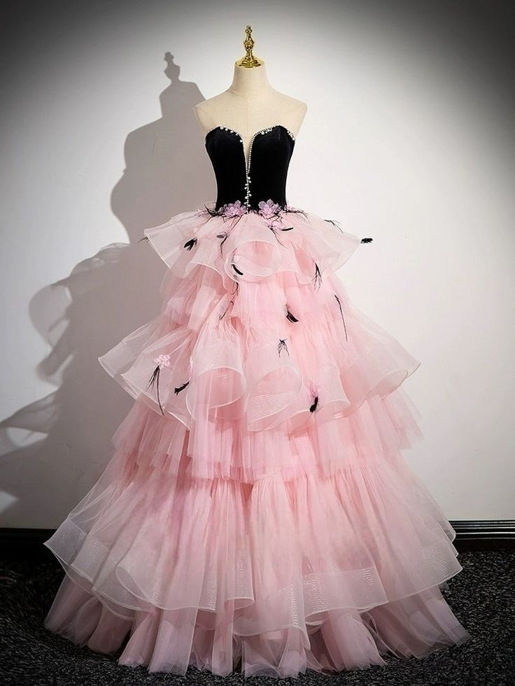 Make a glamorous statement at your next soirée with our Black and Pink Tulle Party Dress, a spectacular ensemble that perfectly marries boldness with elegance. This striking gown features a luxurious black velvet bodice that gracefully transitions into a vibrant pink tulle skirt, setting a dramatic and fashionable tone. Adorned with charming pink floral accents, the skirt brings a playful and romantic flair to the design. A dazzling crystal-embellished waistline draws the eye, accentuating your curves with sophistication. Ideal for upscale parties or as a distinctive choice for an evening gown, this dress ensures that all eyes will be on you. Step into the night with confidence and style in this exquisite pink evening gown, tailored to celebrate plus-size beauty. Black Tulle Ball Gown For Party, Tulle Ball Gown For Prom Gala, Tulle Ball Gown For Prom And Gala, Black Organza Evening Dress For Wedding, Tulle Ball Gown For Gala, Gala Ball Gown In Tulle, Black Organza Evening Dress For Prom, Gala Ball Gown Evening Dress For Debutante Ball, Velvet Ball Gown For Wedding