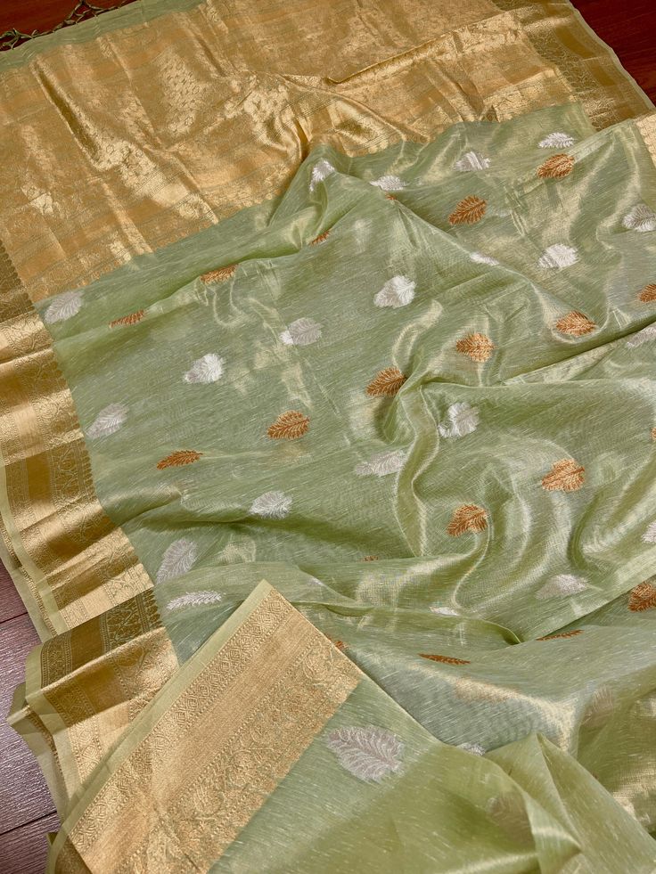 Beautiful Pista Green color Linen Soft Silk Saree with Weaved Buttas all over. Saree is super light weight and very Stable. Copper and Sliver Buttas on the body of the Saree while the Border and Pallu is Matt Gold. Please note - Since the material is tissue, it might looks lighter in shade in sunlight and darker in room-light specially in yellow light. Item : SareeColor : Pista GreenBase Fabric : Linen Soft Tissue Silk Blouse piece : YesBlouse material : Linen Soft Tissue Silk Transparent (Yes/N Festive Pista Green Slub Silk Dupatta, Pista Green Slub Silk Dupatta With Cutdana, Pista Green Slub Silk Dupatta For Diwali, Festive Pista Green Cotton Silk Blouse Piece, Pista Green Slub Silk Traditional Wear For Festivals, Festival Pista Green Slub Silk Traditional Wear, Festival Traditional Pista Green Slub Silk Wear, Pista Green Cotton Silk Dupatta With Zari Work, Pista Green Cotton Silk Dupatta With Cutdana