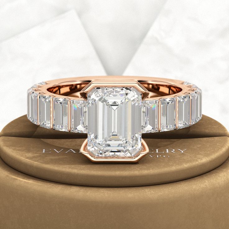 an emerald - cut diamond ring with baguets sits on top of a box