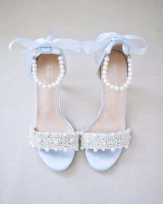 a pair of blue shoes with pearls on them