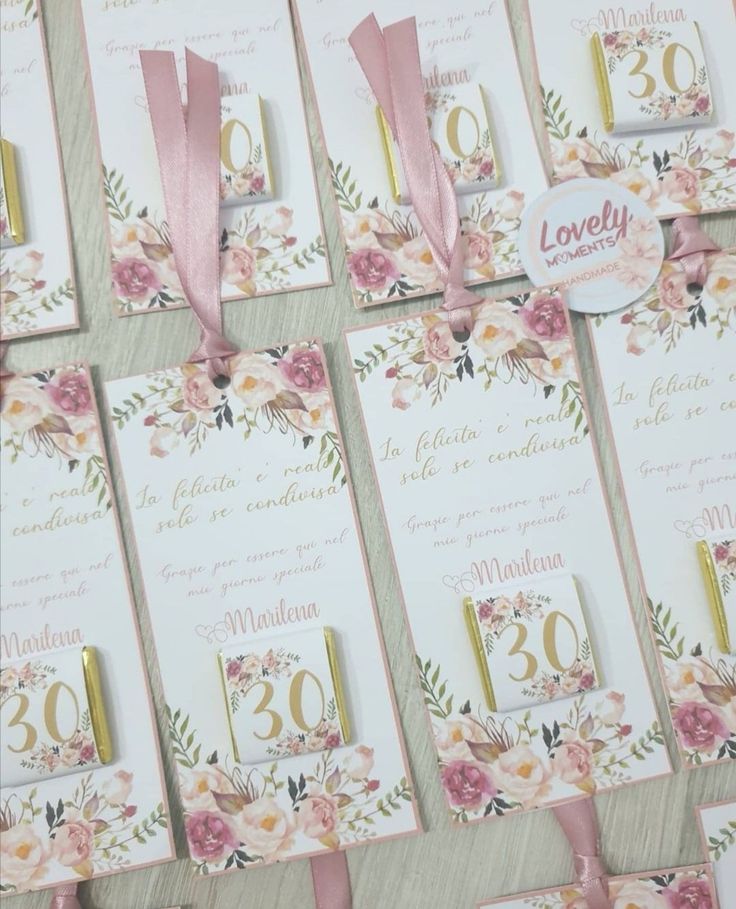 wedding stationery with pink flowers and gold numbers for guests to sign on the table