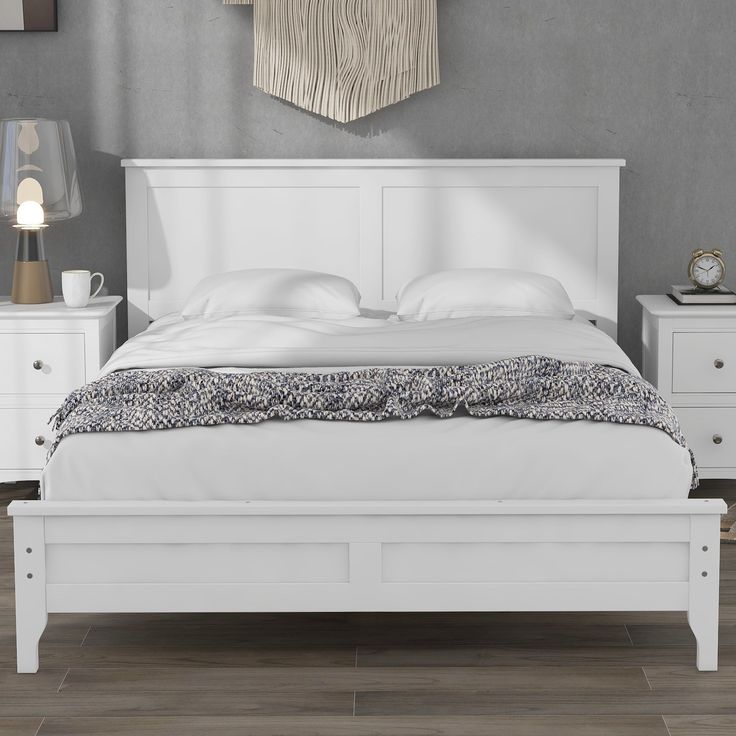 a white bed sitting on top of a wooden floor