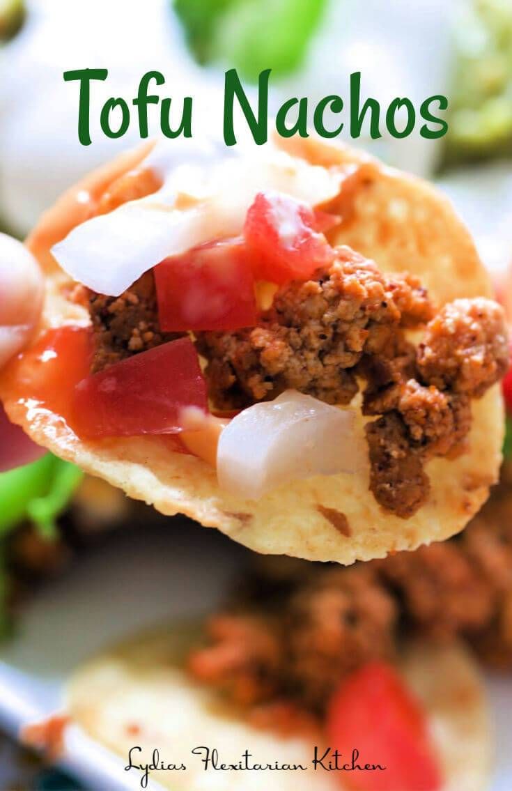 a close up of food on a spoon with the words tofu nachos above it