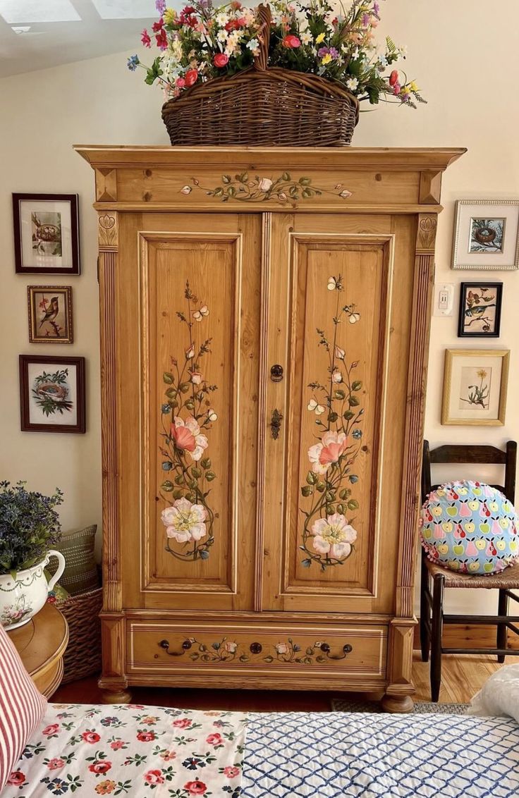 a wooden armoire with flowers painted on it