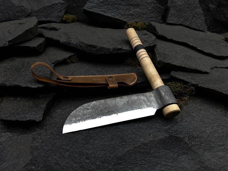 a knife with a wooden handle laying on some rocks