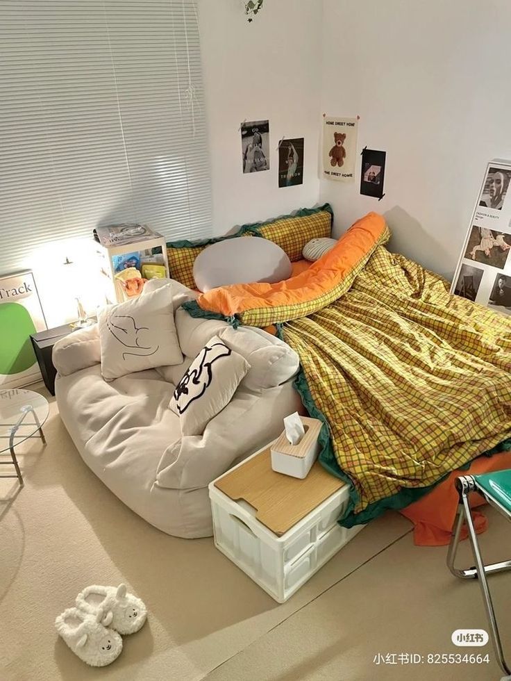 an unmade bed in the corner of a room with pictures on the wall above it