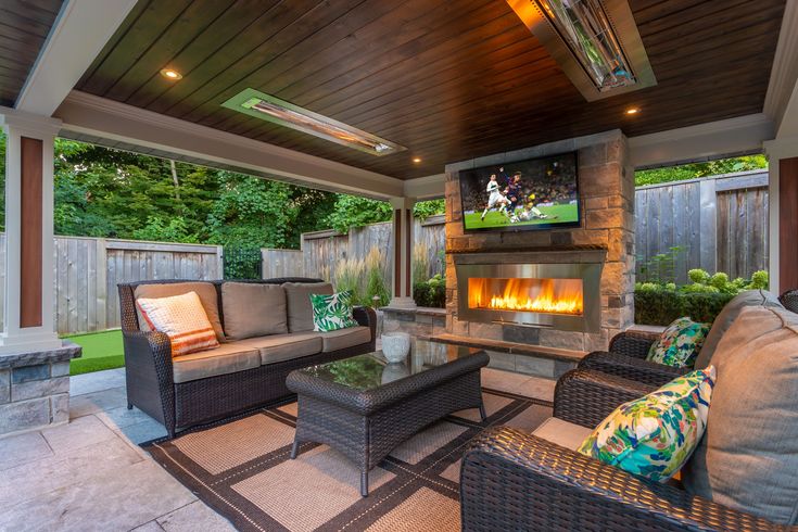 an outdoor living room with fireplace and seating