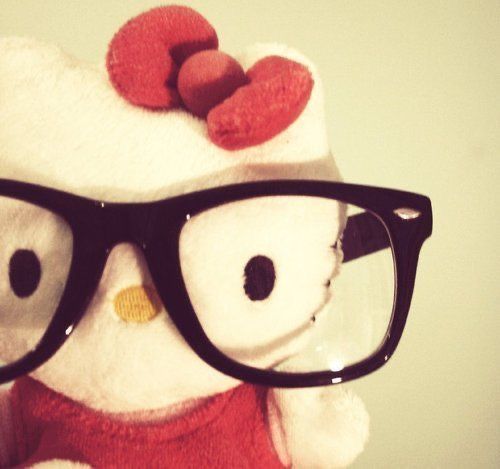 a white teddy bear wearing glasses and a red dress