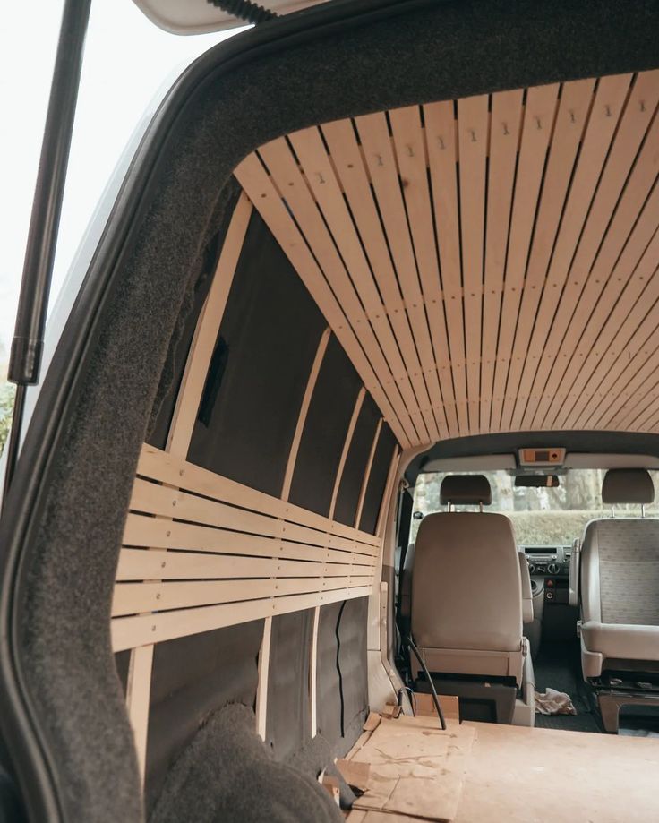 the interior of a van with wood paneling on the walls and seats in it