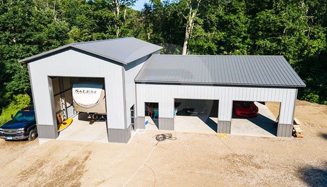 an overhead view of two garages with cars parked in the driveway and trees behind them