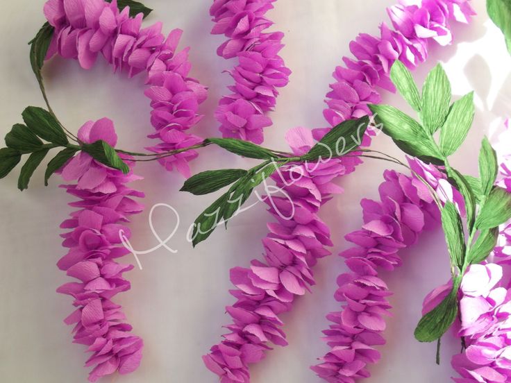 purple flowers are arranged on a white surface