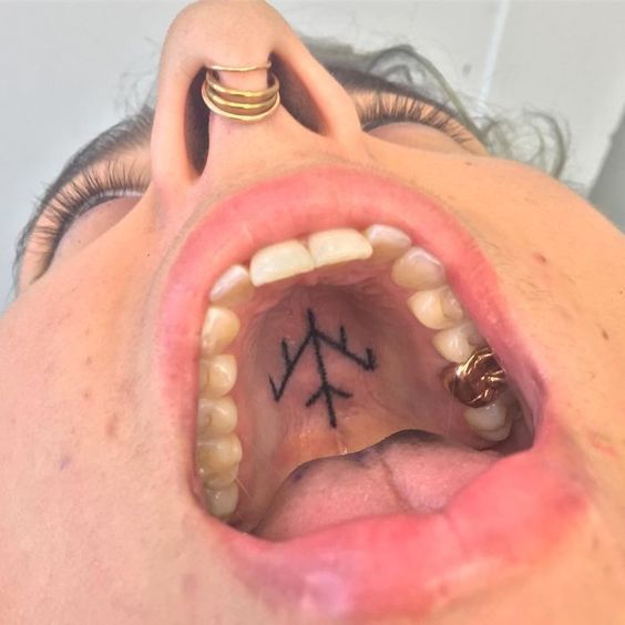 a man with an arrow tattoo on his nose