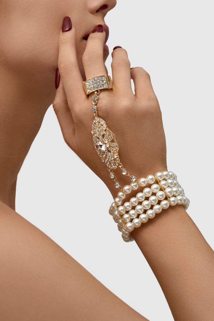 This sumptuous piece of jewelry features a retro-elegant yet slightly modern style that complements the lavish garments, reminiscent of the roaring 1920s. Features: High quality Austrian crystals and imitation pearls Four strand design Inner perimeter of bracelet is 7.4"/ 18.8cm Diameter of ring: 0.7"/ 1.78cm Elegant Crystal Bracelet For Evening, Glamorous Pearl White Jewelry For Party, Glamorous Pearl White Party Jewelry, Evening Pearl Bracelet Jewelry, Pearl Bracelet Jewelry For Parties, Pearl White Bracelet Jewelry For Party, Vintage Pearl Bracelets For Parties, Luxury Adjustable Pearl Bracelet For Party, Elegant Beaded Pearl Crystal Bracelet