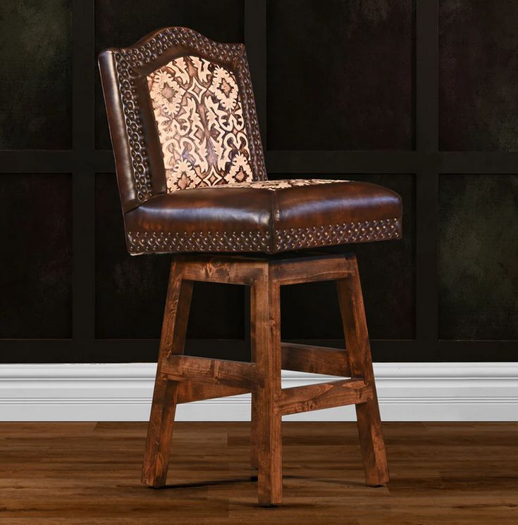 a brown leather chair sitting on top of a hard wood floor next to a wall