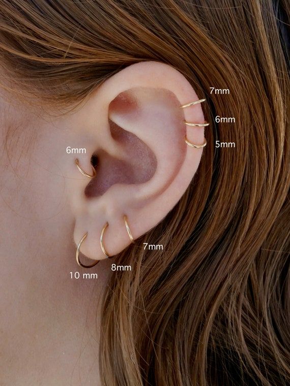 an ear with three different types of piercings on the top and bottom of it