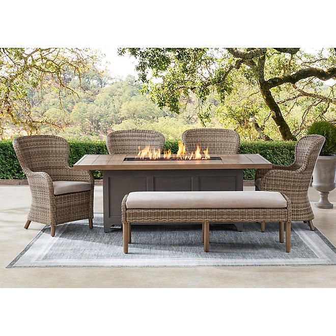 an outdoor table with chairs and fire pit