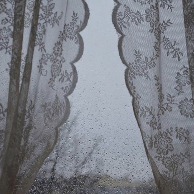 an open window with curtains and lace on it