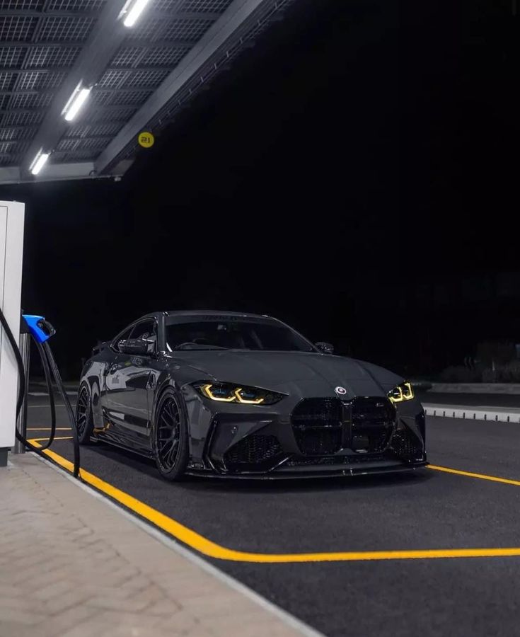 a black sports car parked at a gas station