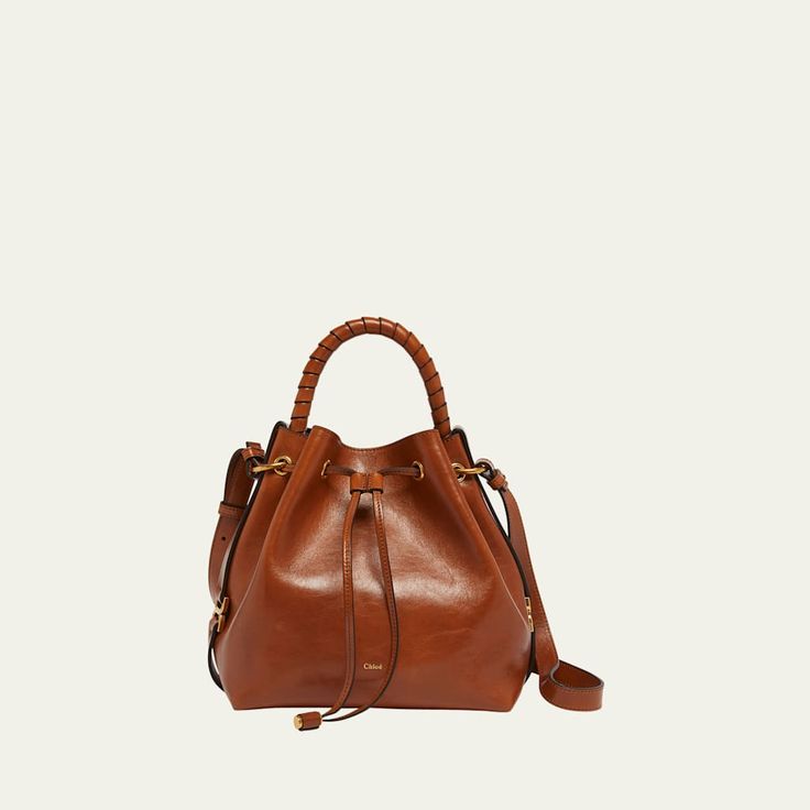 Chloe "Marcie" bucket bag in shiny calfskin  Rolled top handle  Adjustable crossbody strap Can be worn as a top handle or crossbody bag  Drawstring closure  Lining: Leather Approx. 9.4"H x 10.2"W x 5.9"D Made in Italy Luxury Bucket Bag Satchel With Handle Drop, Timeless Brown Bucket Bag With Detachable Strap, Luxury Crossbody Bucket Bag, Luxury Bucket Satchel With Detachable Handle, Leather Bucket Bag With Detachable Strap And Double Handle, Luxury Leather Bucket Bag With Handles, Formal Crossbody Bucket Bag With Leather Handles, Luxury Bucket Hobo Bag With Detachable Handle, Timeless Leather Crossbody Bucket Bag