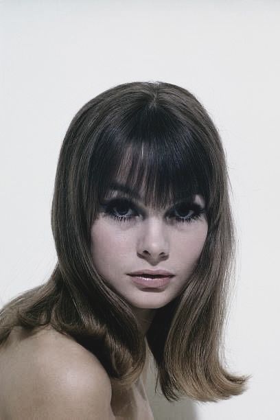 a woman with long hair and bangs posing for the camera