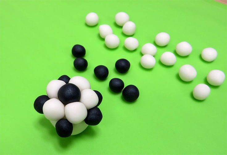 some black and white balls are on a green surface