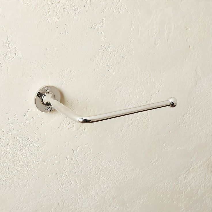 a white toilet paper roll holder on the wall with a metal bar attached to it