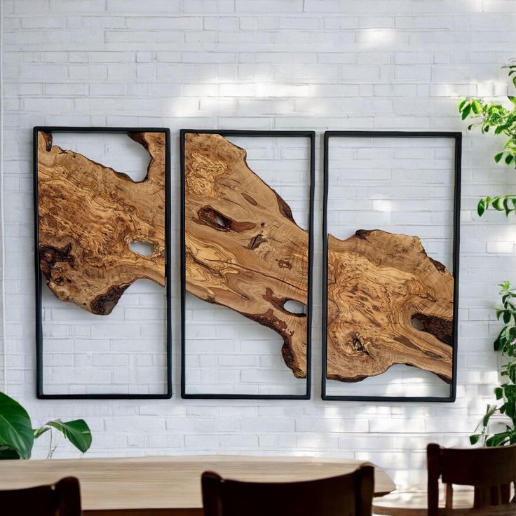 three pieces of wood sitting on top of a table in front of a white brick wall