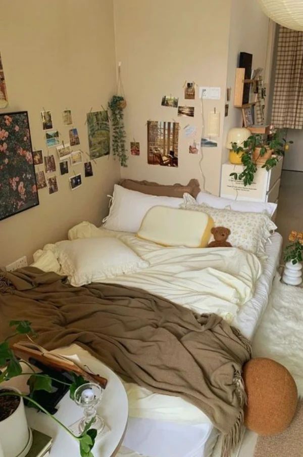 a bed room with a neatly made bed and lots of pictures on the wall above it