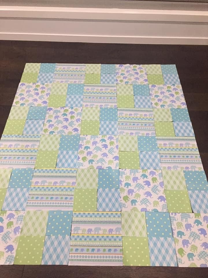 a patchwork table runner made with blue and green squares, flowers and stripes on it