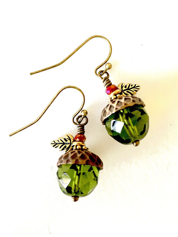 Beautiful translucent 12 mm olive olivine faceted Czech glass beads topped with "Vintaj" artisan bronze acorn bead caps. Earrings are wire wrapped in bronze and accented with darling little antique gold TierraCast two sided oak leaf charms, antique gold daisies and tiny iridescent burnt orange Czech crystals. They hang from vintage bronze French ear hooks. Length is 1 1/4".  So fun for fall! Acorn Cap Earrings, Fall Earring, Acorn Caps, Acorn Earrings, Vintage Jewelry Crafts, Pumpkin Earrings, Fall Earrings, Oak Leaves, Earrings Inspiration