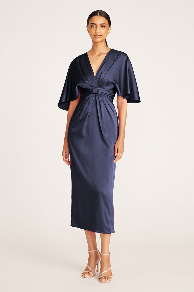 The Lucia Dress is cut from lustrous satin back crepe, one of our signature fabrications. Framed by a V-neckline, it features draped sleeves, a waistband with ruched details and a form-flattering skirt. This season, slip on a style that embodies the beauty of the modern woman. V-Neck Sheath Silhouette Non-Stretch Elbow Sleeve Tea Length REF: 8815583 Theia Couture, Butterfly Sleeve Dress, Satin Cocktail Dress, V Neck Midi Dress, Navy Midi Dress, Mother Of The Bride Dress, Dress Purchase, Kimono Dress, Tea Length