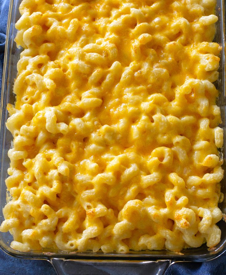 macaroni and cheese in a casserole dish on a blue cloth,