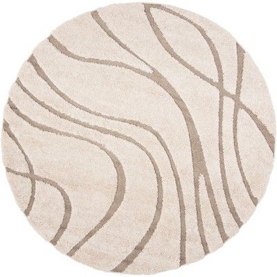 a round rug with wavy lines on the top and bottom in beige, white and grey