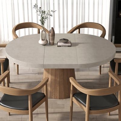 a round table with four chairs around it and a vase on the table next to it