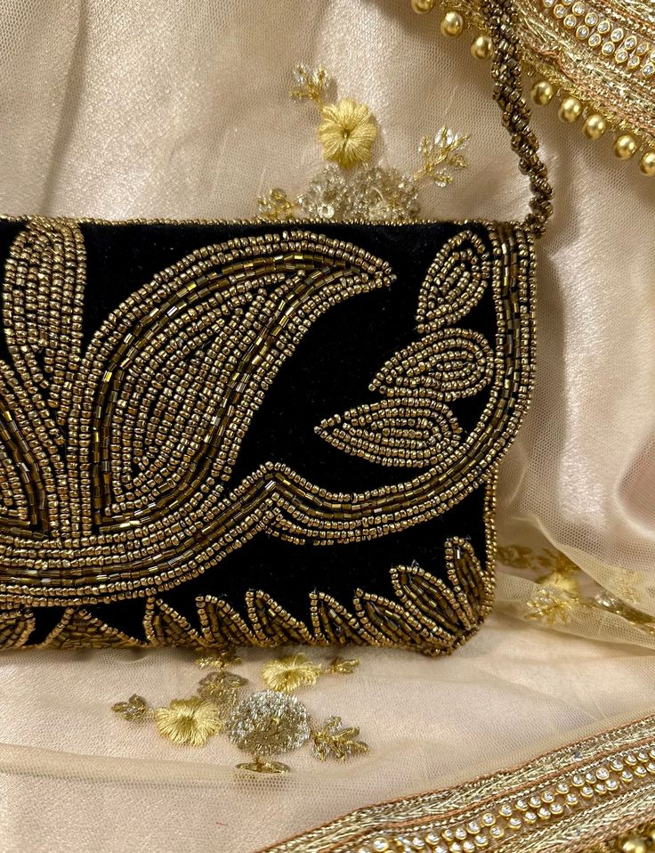 Introducing our exquisite golden beaded and sequined velvet clutch, an elegant accessory that seamlessly blends luxury with functionality. Crafted from plush velvet, this clutch features a stunning design adorned with intricate golden beads and sequins that create a mesmerizing shimmer, perfect for evening events or special occasions. The soft velvet texture not only adds sophistication but also ensures a comfortable grip. The clutch is beautifully structured to hold your essentials while mainta Bohemian Clutch, Evening Clutches, Beaded Clutch Bag, Pearl Clutch, Golden Beads, Velvet Clutch, Velvet Texture, Embroidered Clutch, Black Clutch