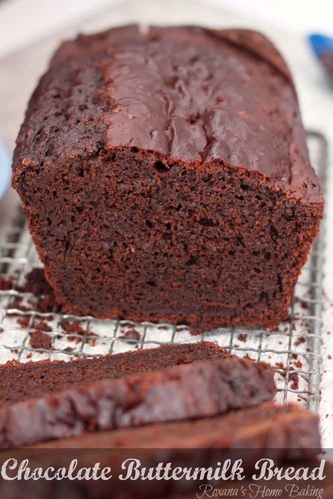 a loaf of chocolate buttermilk bread sitting on a cooling rack next to another loaf