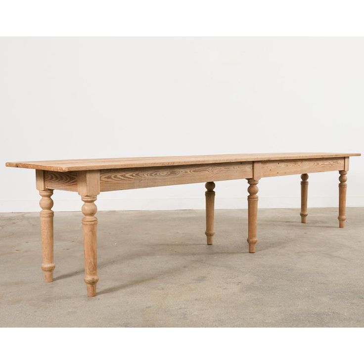 an old wooden table sitting on top of a cement floor