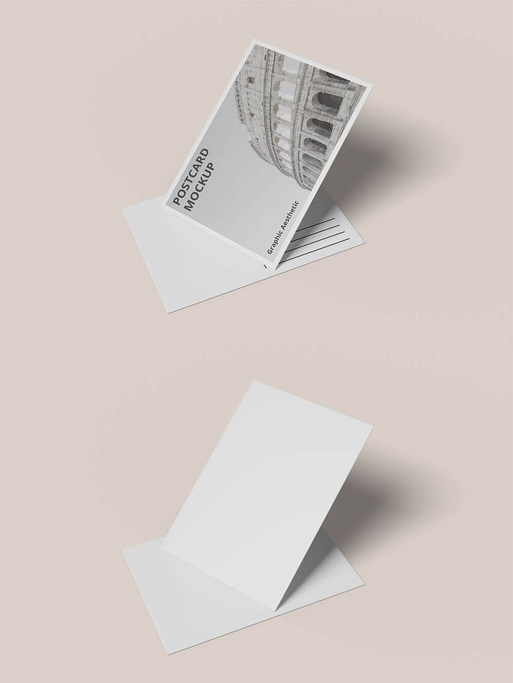 two folded business cards on top of each other with an image of a building in the background