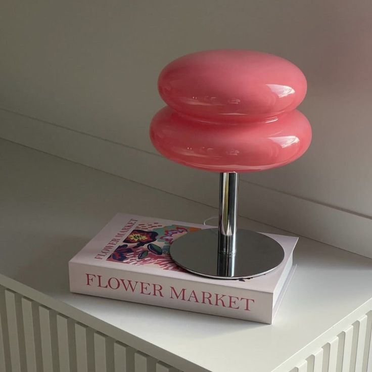 a pink lamp sitting on top of a book