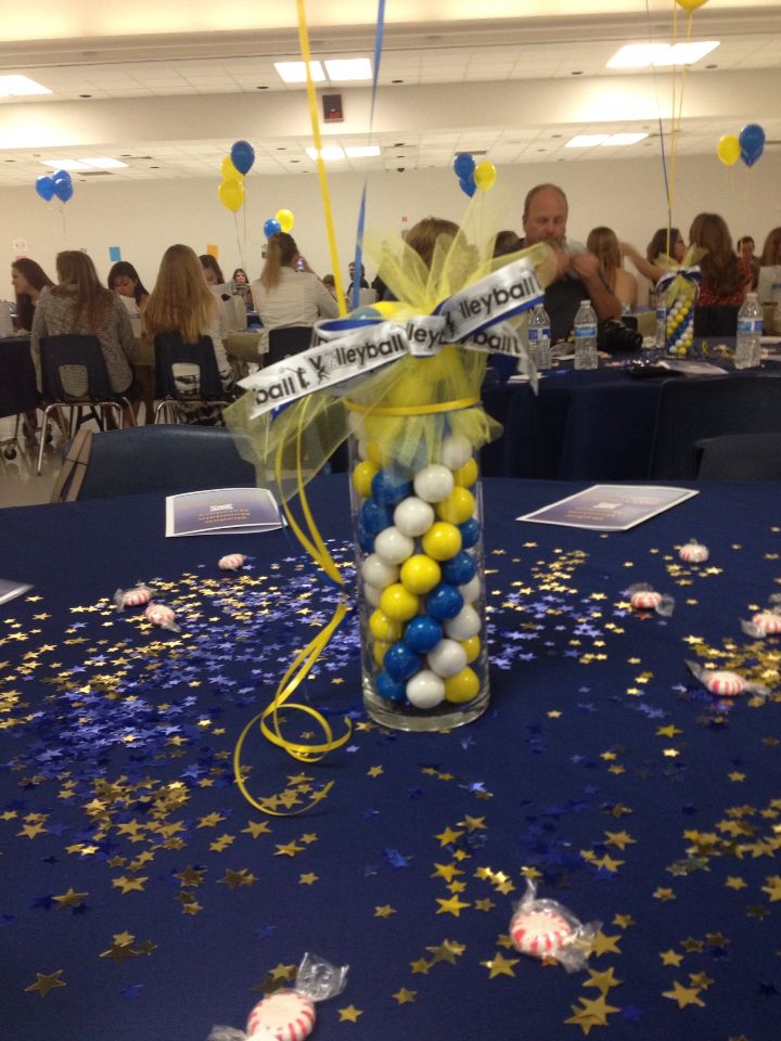 a vase filled with balloons and confetti on top of a blue table cloth