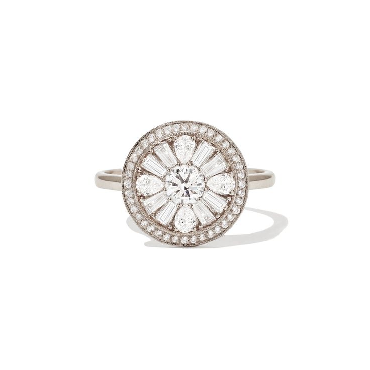 a white gold ring with an oval shaped diamond surrounded by small round brilliant cut diamonds