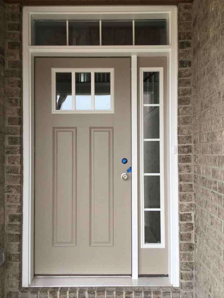 the front door to a home with brick walls and white trim on the side walk