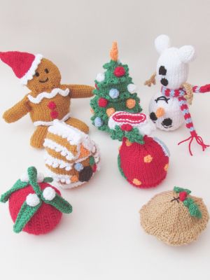 crocheted christmas ornaments are arranged on a white surface with one stuffed animal and the other knitted ornament