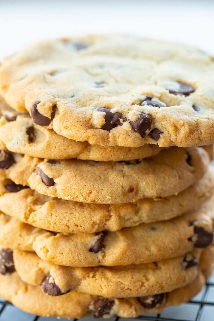 a stack of chocolate chip cookies sitting on top of a cooling rack